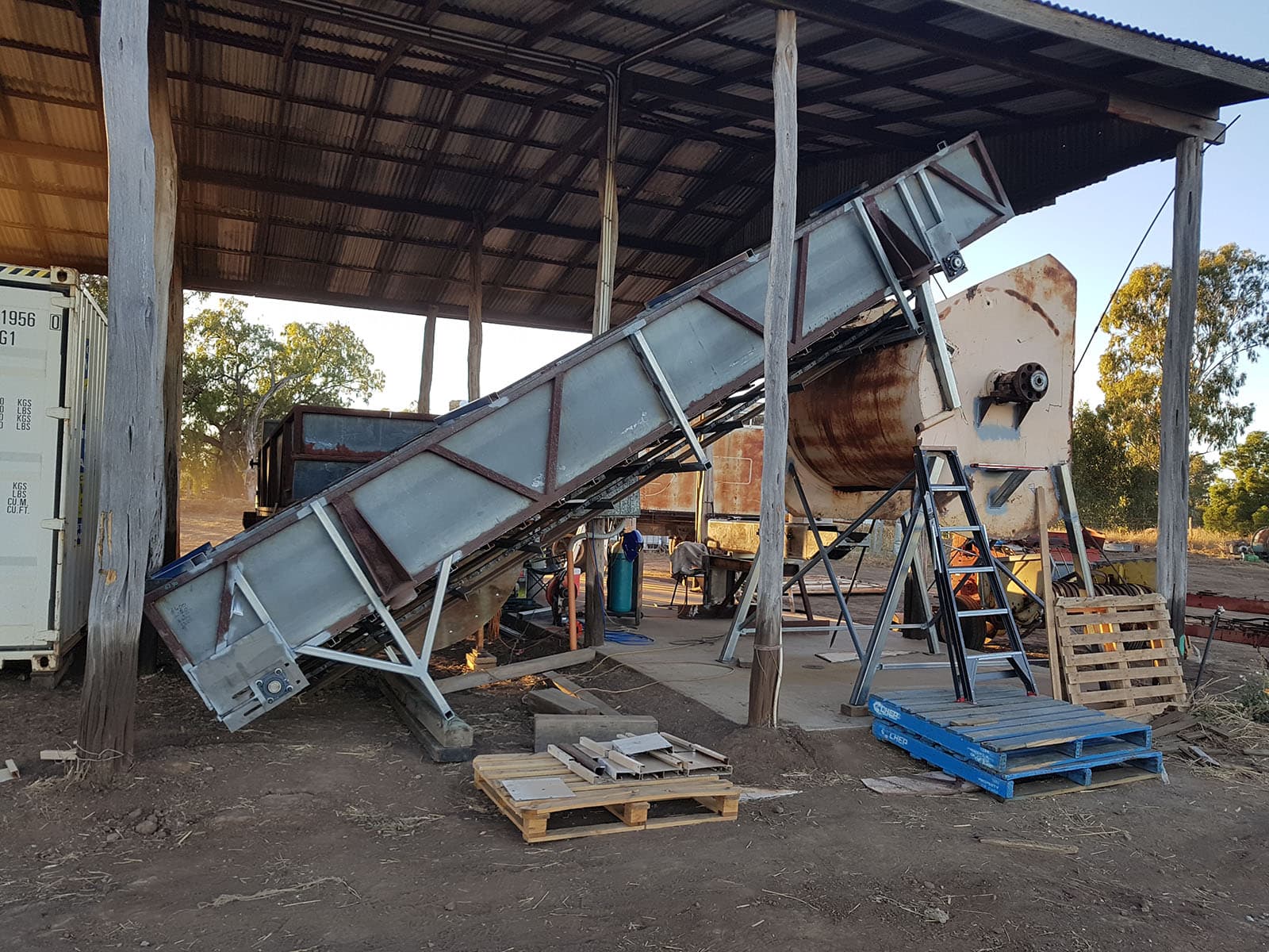 Conveyor belt machinery installed under a shed roof at the Alfa Vital processing site