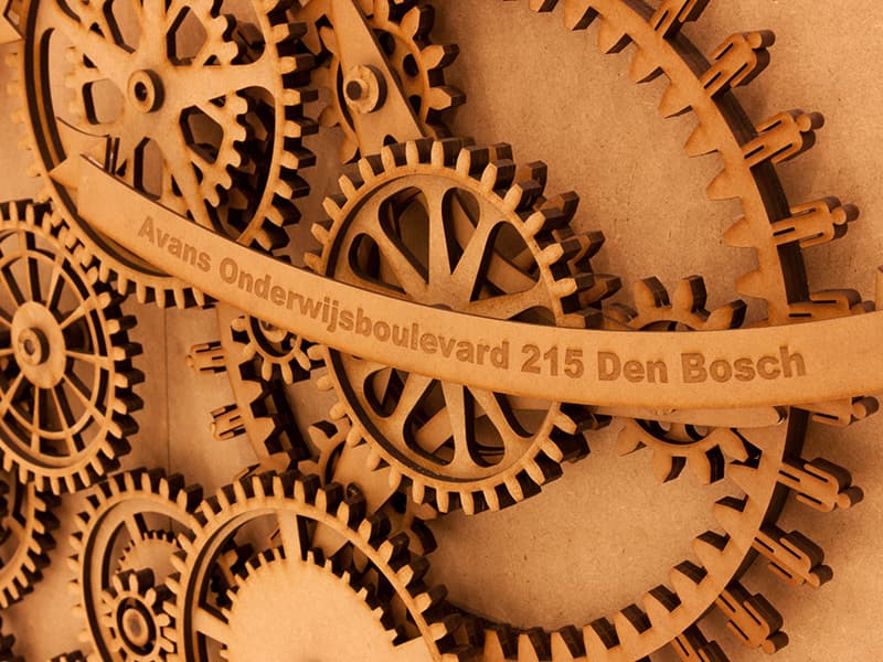 Close-up of a laser-cut gear labelled with an AVANS University campus address